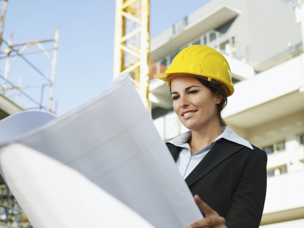 female engineer looking at blueprints in construction site