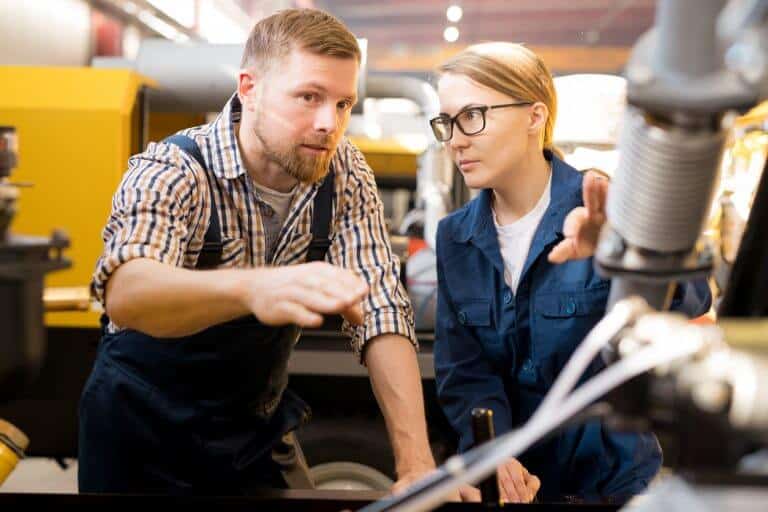 man and woman looking at spring machine