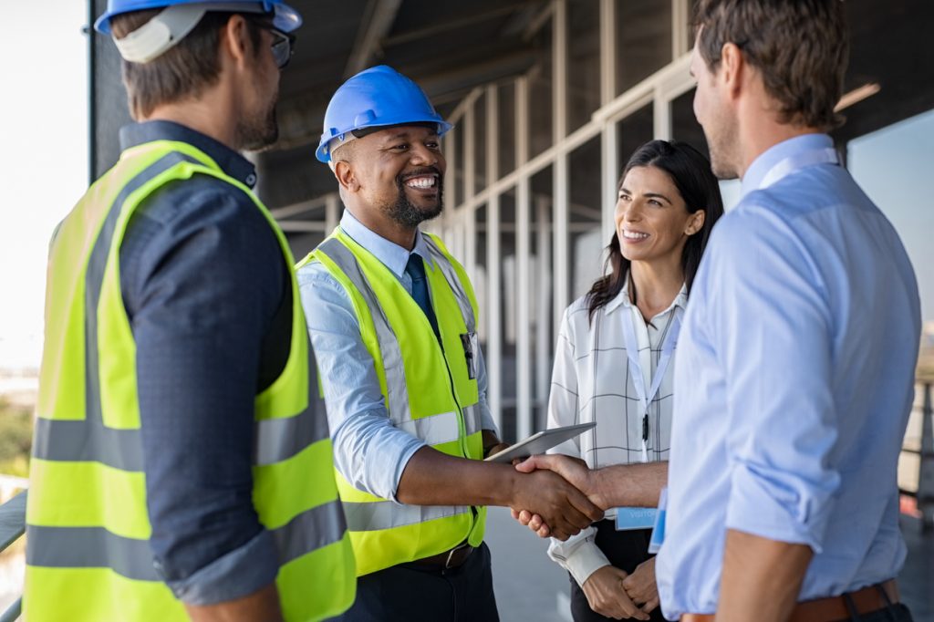 Engineers shaking hands with clients on a worksite