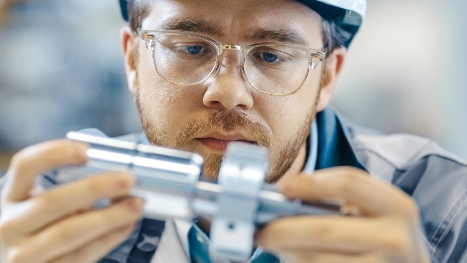 Man looking closely at a metal object