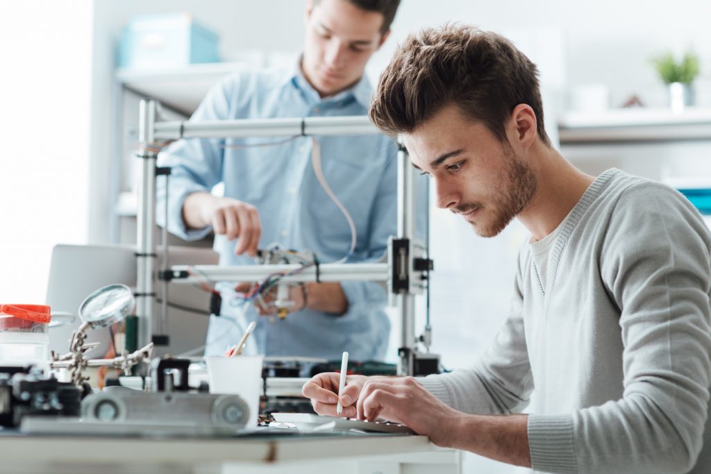 Two engineering and manufacturing apprentices working on a practical assignment