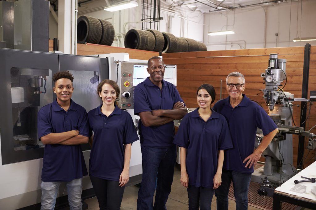 Engineering apprentices stood with their tutor smiling