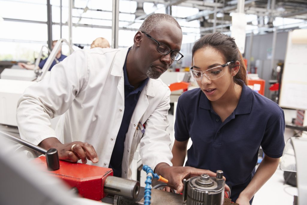 Engineering tutor and apprentice completing a practical assigment