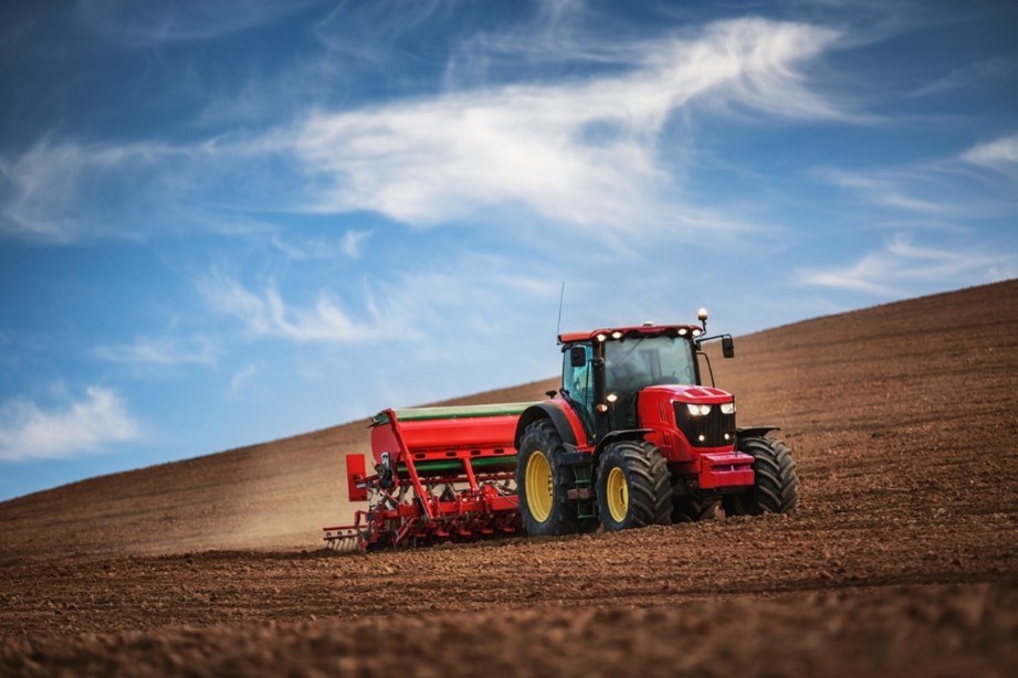 Red tractor driving through a field