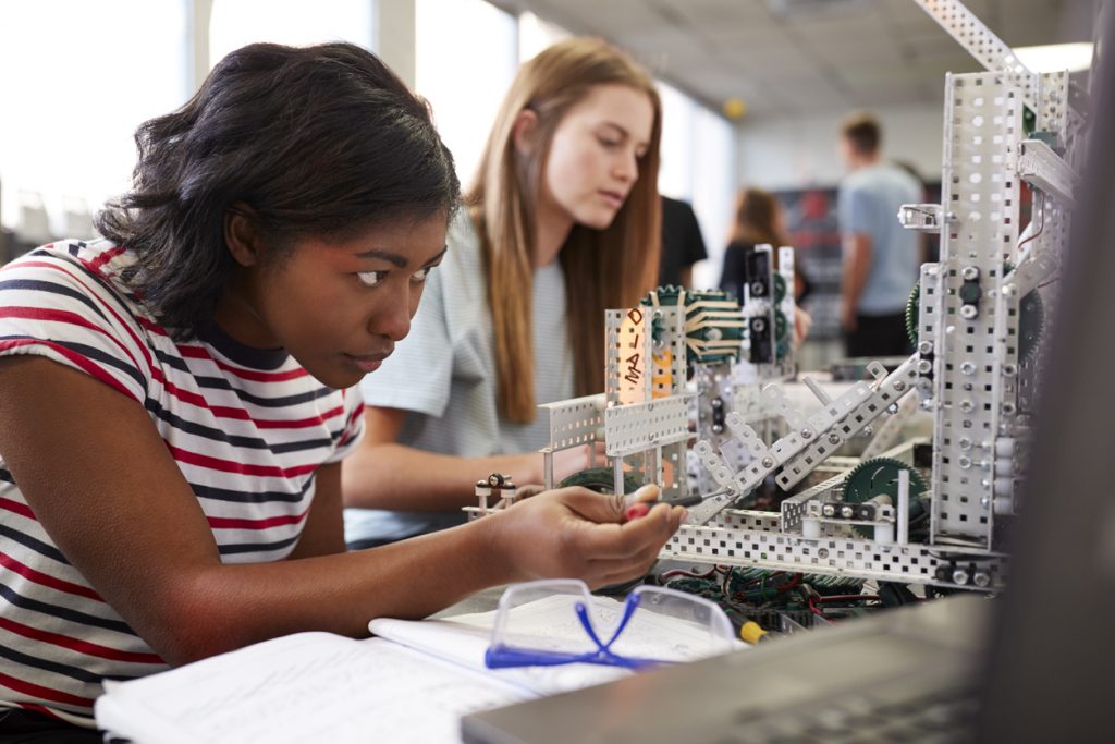 Two female STEM students working on a manufacturing project