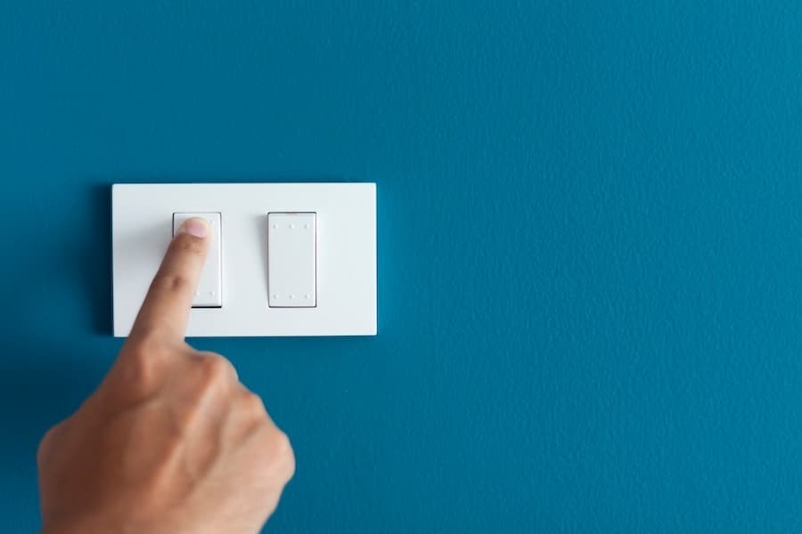 A finger pressing a light switch